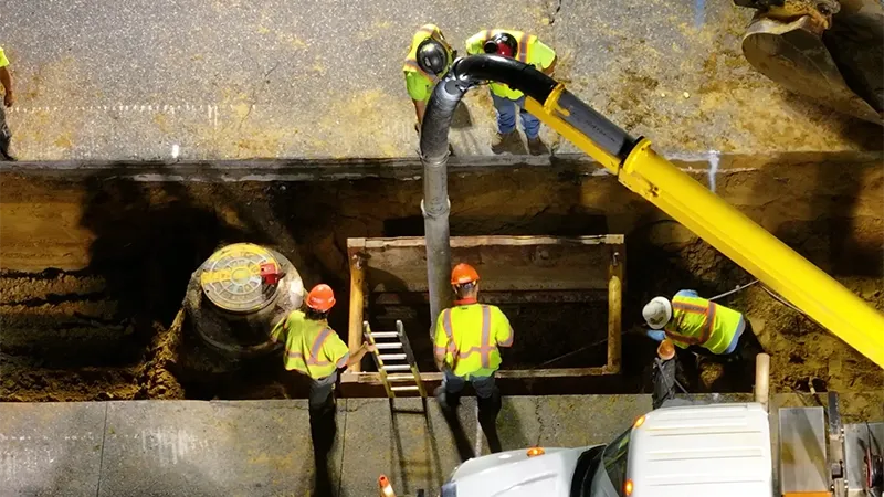 Workers are working at a construction site with heavy machinery and equipment.