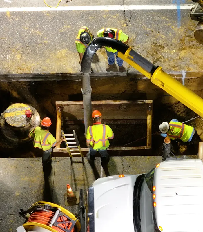 Workers are working at a construction site with heavy machinery and equipment.
